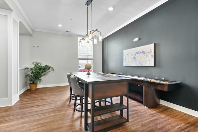 dining space featuring baseboards, recessed lighting, wood finished floors, and crown molding