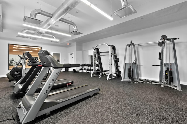 gym featuring a garage, visible vents, and baseboards