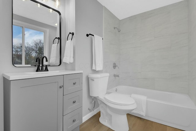 bathroom featuring  shower combination, toilet, wood finished floors, and vanity