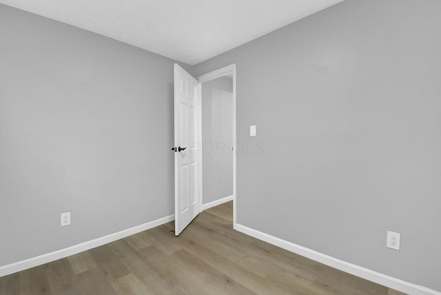 empty room with wood finished floors and baseboards