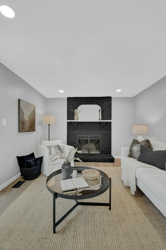 living room featuring recessed lighting, a fireplace, visible vents, and baseboards