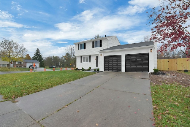 colonial house with a front yard, driveway, an attached garage, and fence