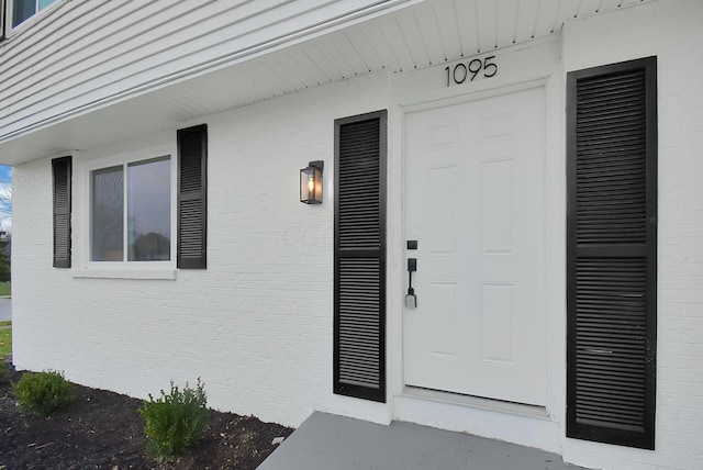 entrance to property featuring brick siding