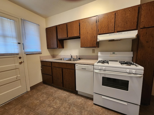 kitchen with light countertops, a sink, white appliances, under cabinet range hood, and baseboards