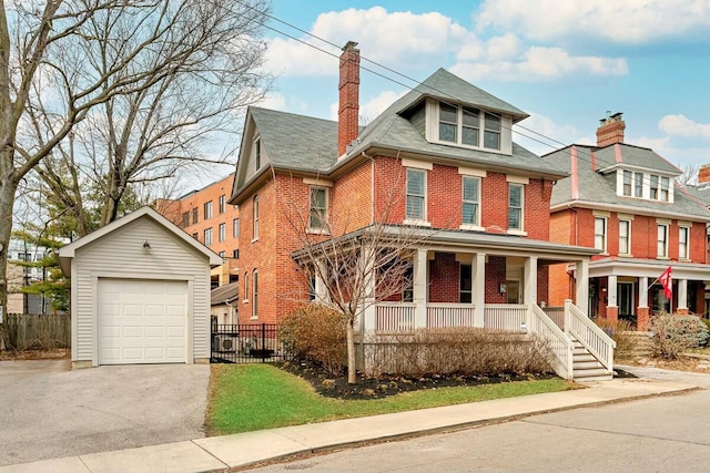 traditional style home with brick siding, a detached garage, a porch, fence, and an outdoor structure