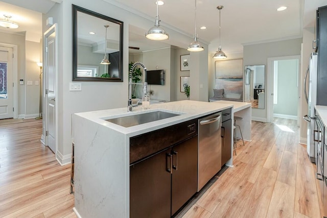 kitchen featuring dishwasher, a sink, light wood-style flooring, and crown molding