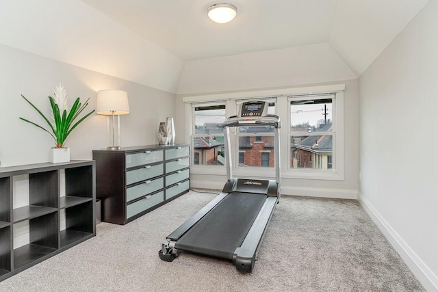 exercise room with lofted ceiling, carpet flooring, and baseboards