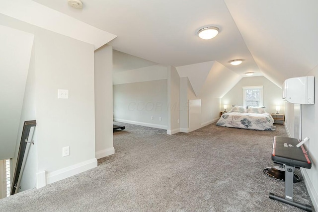 unfurnished bedroom featuring vaulted ceiling, carpet floors, and baseboards