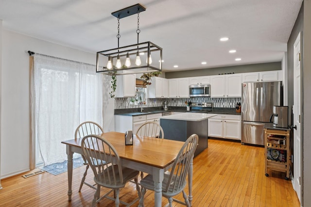 dining space featuring light wood-type flooring, visible vents, and recessed lighting