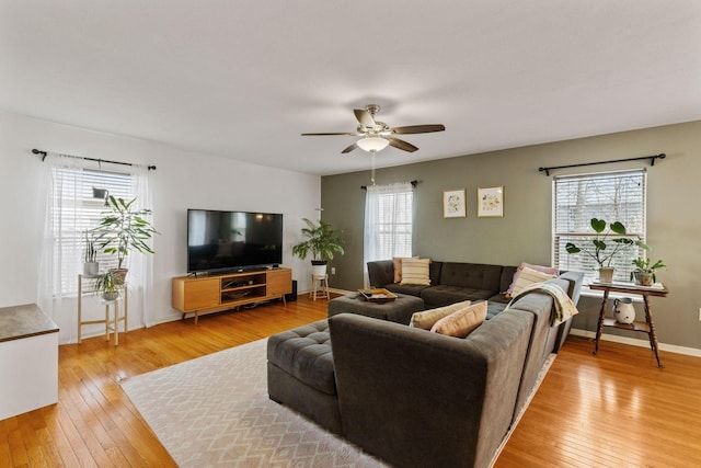 living area with light wood finished floors, baseboards, and a ceiling fan