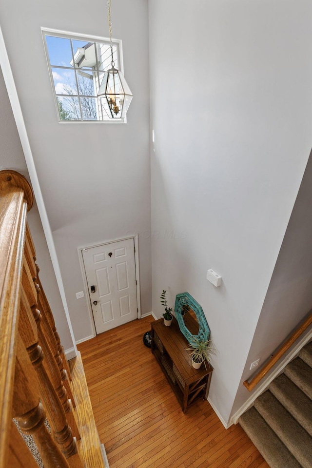 foyer entrance featuring stairway, light wood-type flooring, and baseboards