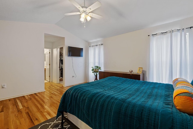 bedroom with light wood-type flooring, vaulted ceiling, baseboards, and ceiling fan