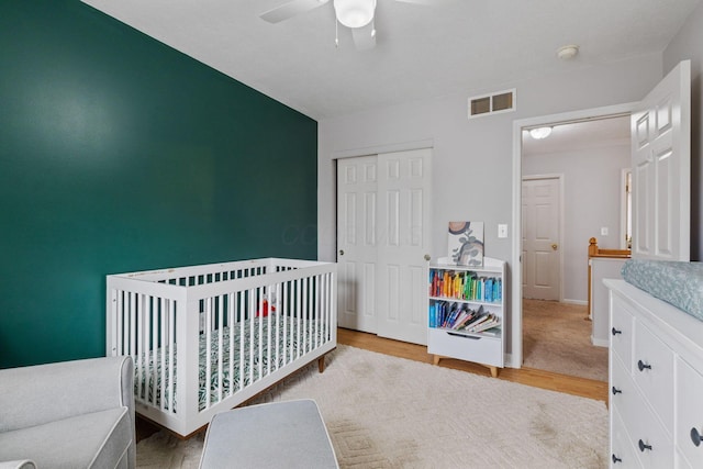 bedroom featuring baseboards, visible vents, a ceiling fan, wood finished floors, and a closet