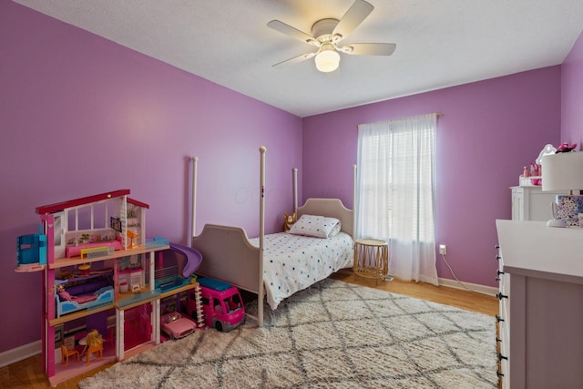 bedroom featuring ceiling fan, wood finished floors, and baseboards