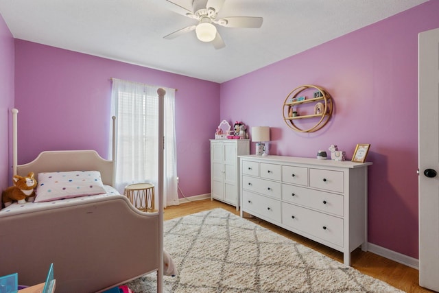 bedroom with light wood-style flooring, baseboards, and a ceiling fan