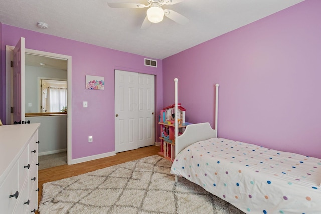 bedroom featuring a closet, visible vents, light wood-style floors, ceiling fan, and baseboards