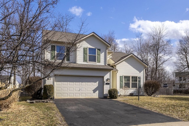 traditional-style home with a garage, roof with shingles, driveway, and fence