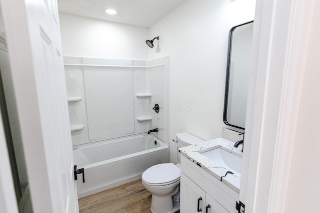 bathroom with vanity, bathtub / shower combination, wood finished floors, and toilet