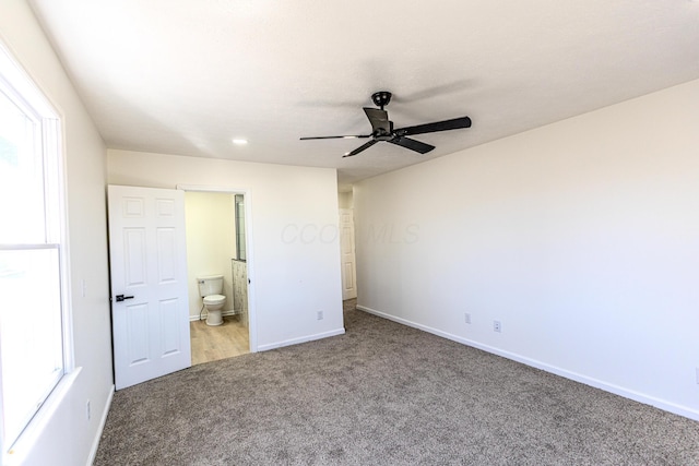 unfurnished bedroom featuring ensuite bath, carpet, baseboards, and a ceiling fan