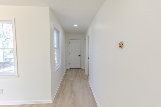 hallway featuring light wood-type flooring, baseboards, and recessed lighting