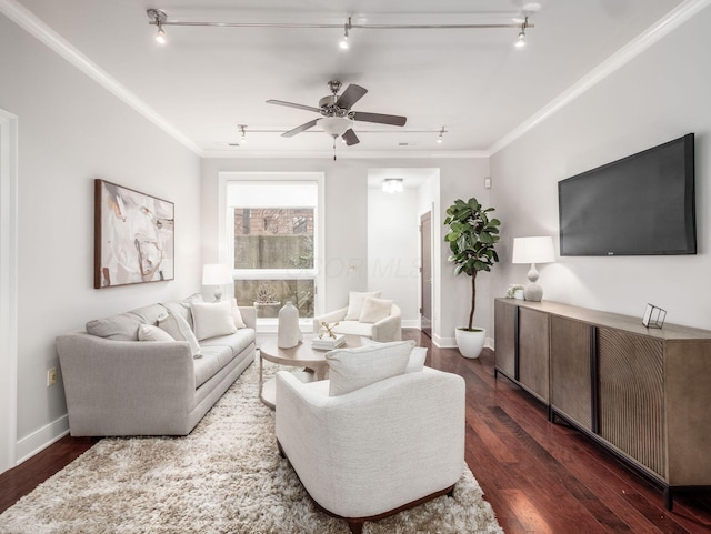 living room with dark wood finished floors, crown molding, ceiling fan, track lighting, and baseboards