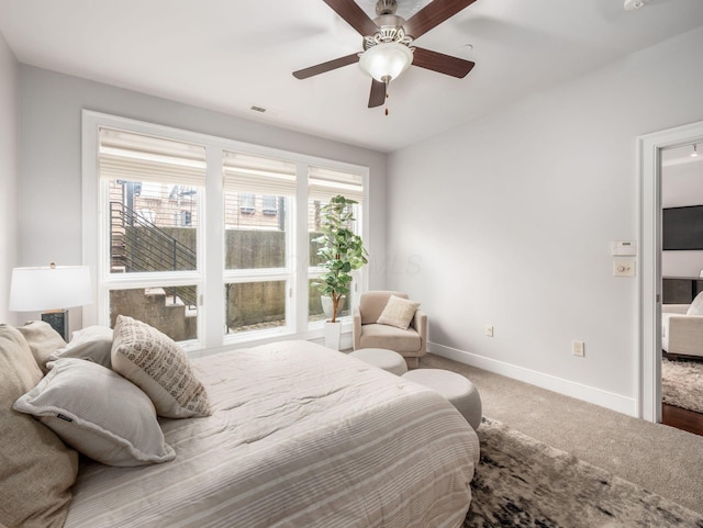 carpeted bedroom featuring ceiling fan, multiple windows, visible vents, and baseboards