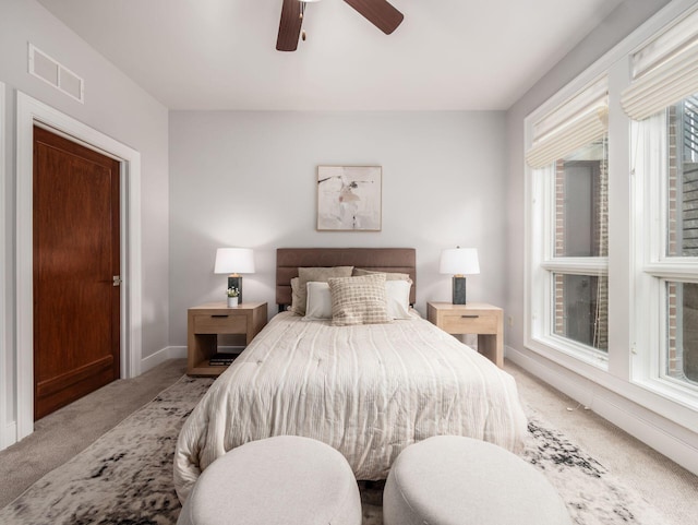 bedroom featuring light carpet, baseboards, visible vents, and a ceiling fan