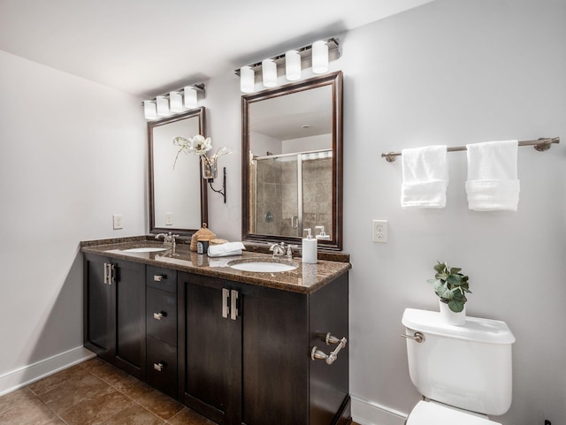 full bathroom with double vanity, a sink, toilet, and a shower stall