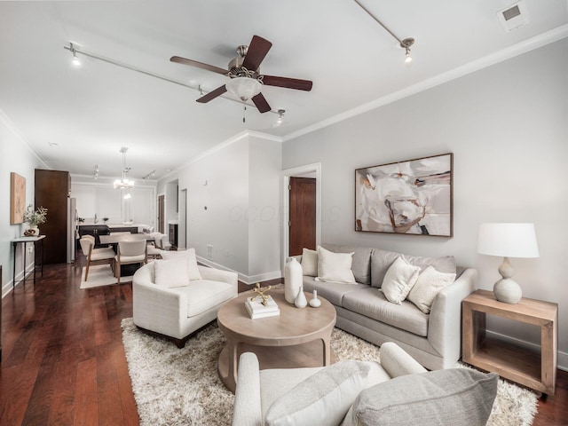 living room with ceiling fan with notable chandelier, visible vents, baseboards, ornamental molding, and dark wood finished floors