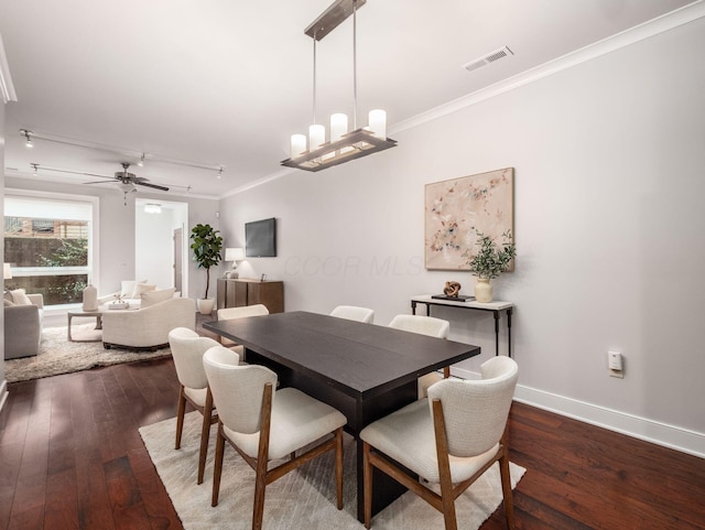 dining room with ornamental molding, hardwood / wood-style flooring, and visible vents