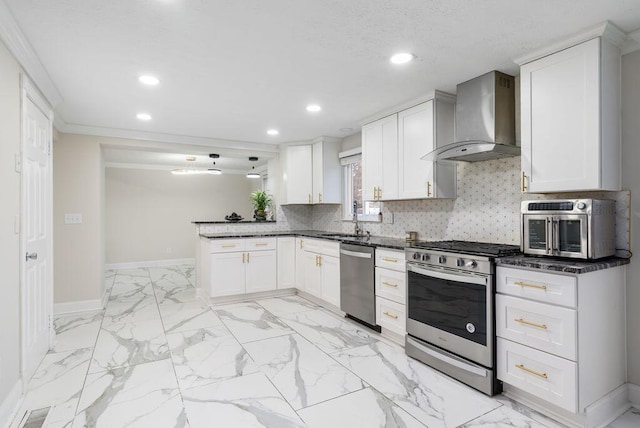 kitchen featuring stainless steel appliances, baseboards, decorative backsplash, and wall chimney exhaust hood