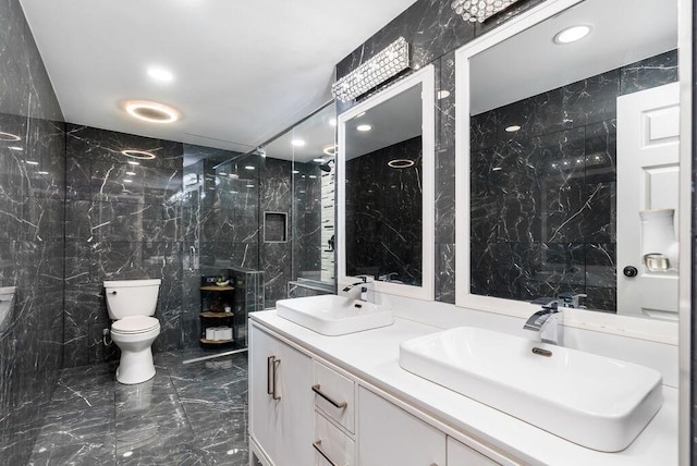 bathroom with marble finish floor, a sink, tile walls, and toilet