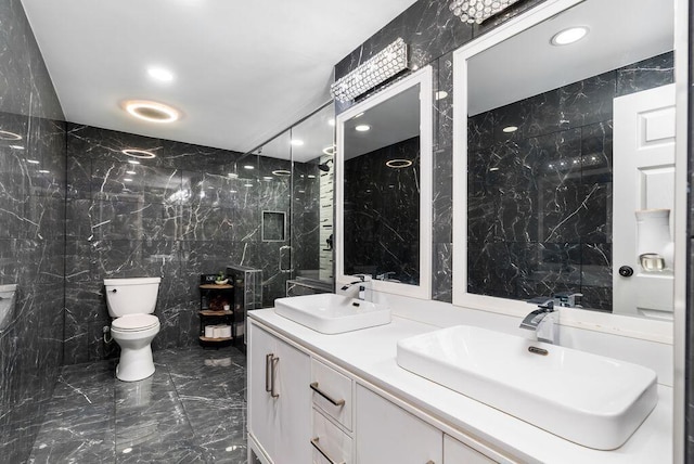 full bathroom featuring marble finish floor, a sink, toilet, and tile walls