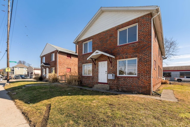 view of front facade with a front yard and brick siding