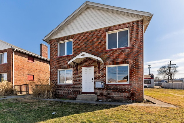 traditional-style home featuring brick siding and a front yard