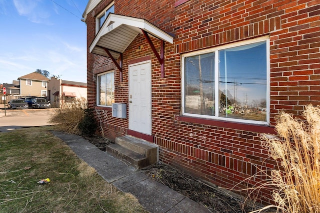 view of side of property featuring entry steps and brick siding