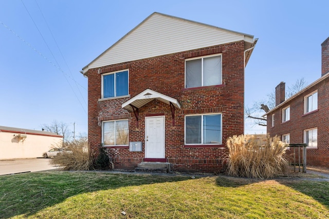 view of front facade with a front yard and brick siding