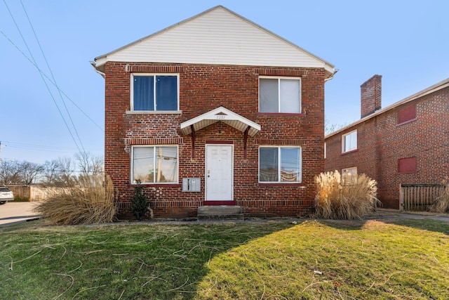 traditional home featuring brick siding and a front yard