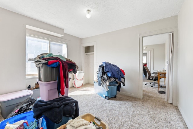 carpeted bedroom with a textured ceiling, baseboards, and a closet