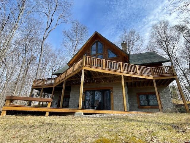 back of house featuring a deck and a chimney