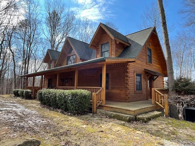 view of home's exterior featuring log siding and a porch