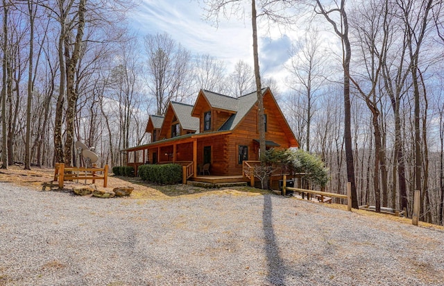 view of front of home with log siding and a deck