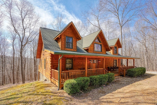 log-style house with roof with shingles and covered porch