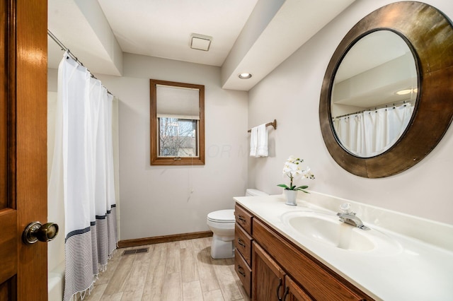 full bathroom featuring vanity, wood finished floors, visible vents, curtained shower, and toilet