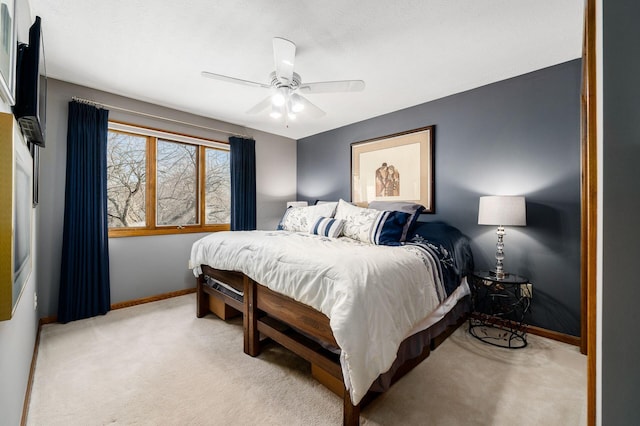 bedroom featuring light colored carpet, baseboards, and ceiling fan