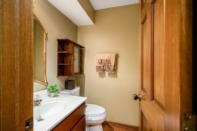 bathroom with vanity, toilet, and baseboards