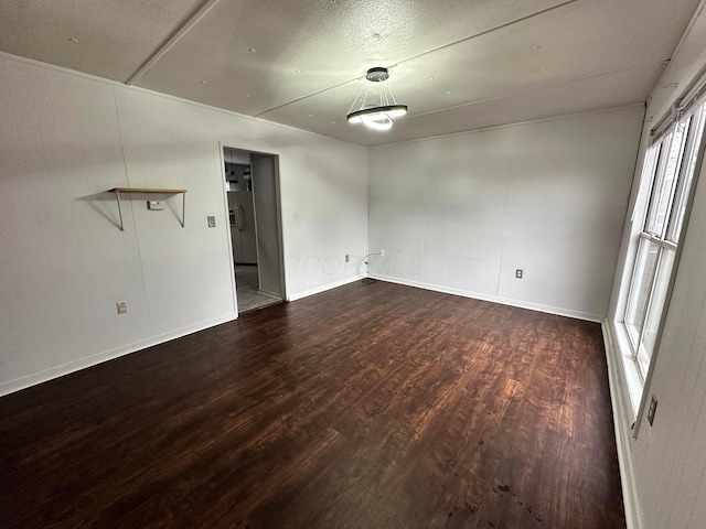 unfurnished room with baseboards and wood finished floors