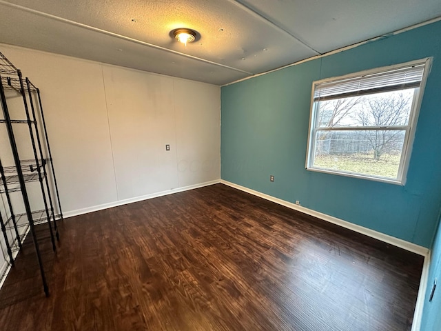 empty room featuring baseboards and wood finished floors