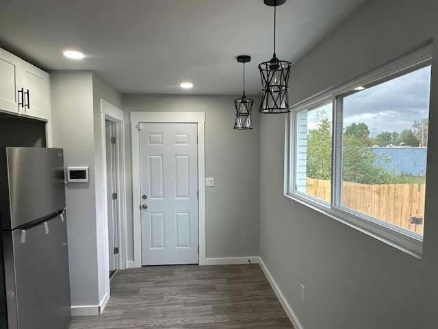 unfurnished dining area featuring dark wood-style flooring, recessed lighting, and baseboards