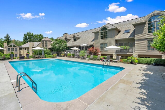 outdoor pool with a patio and a residential view